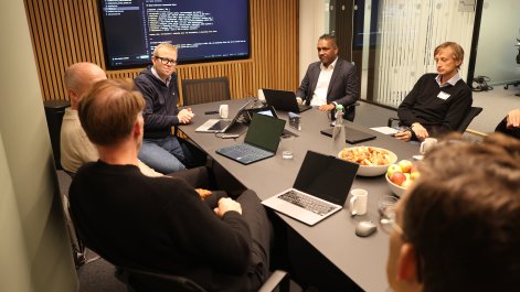 Folks om sitter rundt et bord og diskuterer