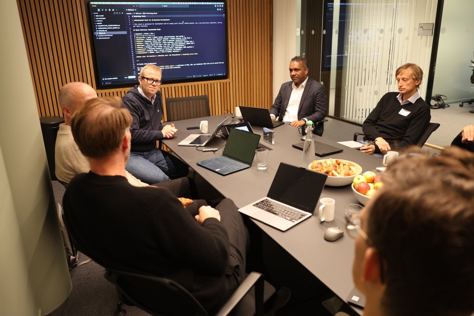 Folks om sitter rundt et bord og diskuterer