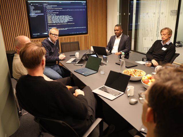 Folks om sitter rundt et bord og diskuterer