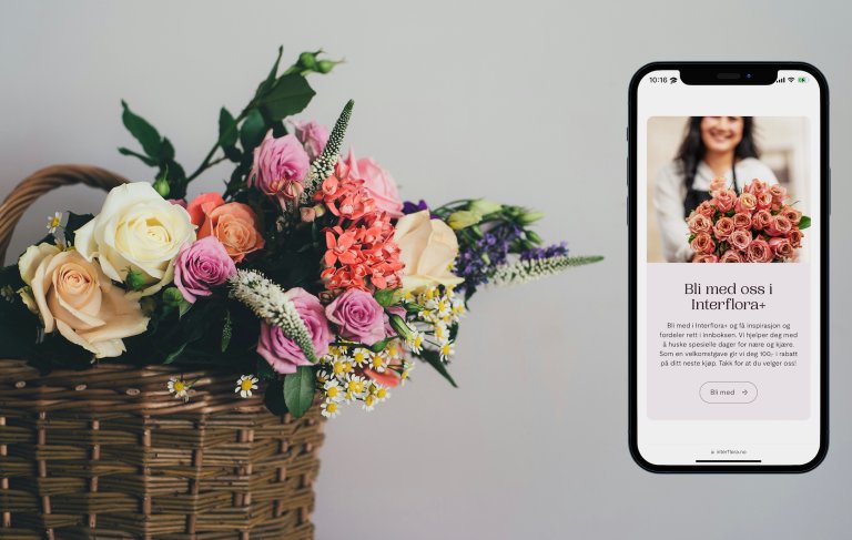 Blomsterkurv og telefon med bilde av nettsiden til Interflora
