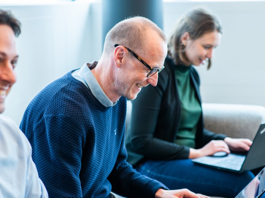 Mennesker som sitter og ser på skjerm.